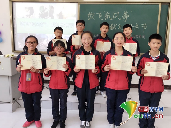 龙里县留守儿童展示自己给母亲制作的节日贺卡。毕克 摄